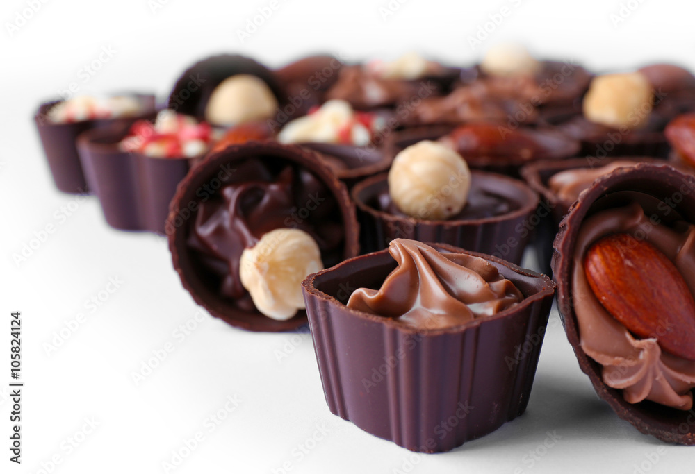 Delicious chocolate candies on white background, close up