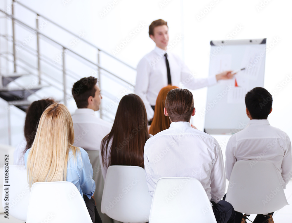 Young businessman making a presentation on a board in the office