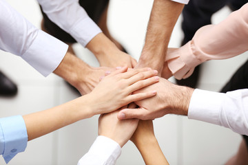 Top view of young people putting hands together