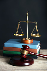 Wall Mural - Wooden gavel with justice scales and books on black background