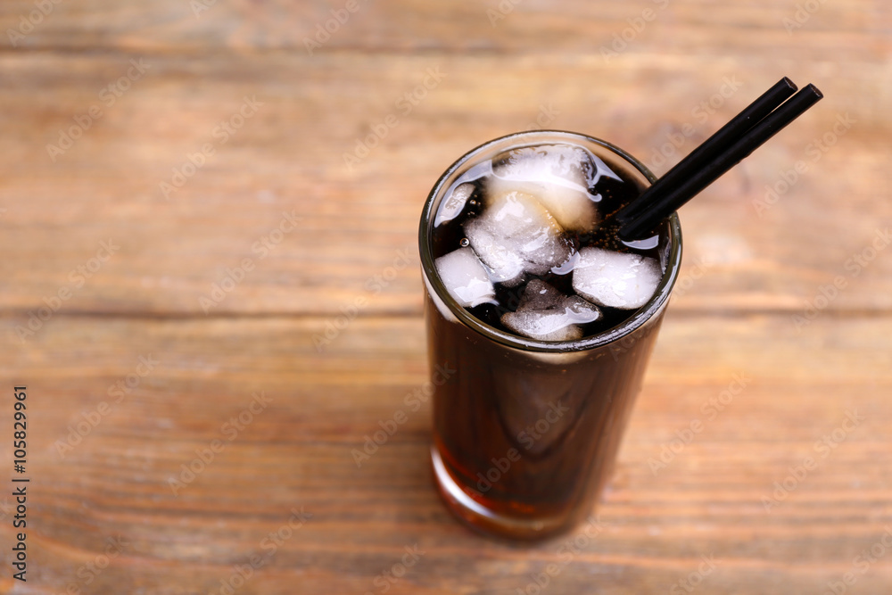 Cocktail with lime slices and ice blocks on wooden table, close up