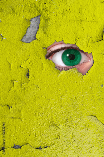Fotografía occhio che spia attraverso un buco nel muro