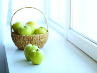 Wall Mural - Ripe green apples in basket on a windowsill
