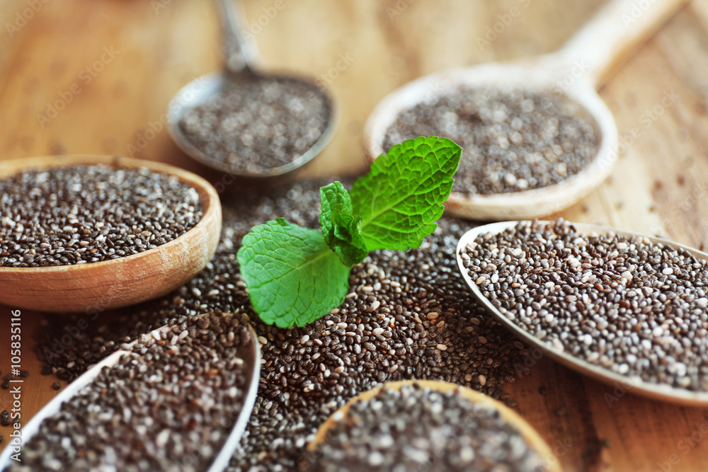 Spoons of chia seeds with mint leaves, closeup