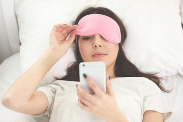 Wall Mural - Beautiful girl lying with an eye mask in the bedroom.