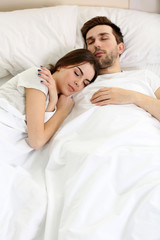 Wall Mural - Young cute couple sleeping together in bed.