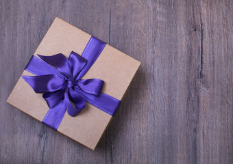 Gift box with bow on wooden background