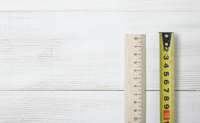 Wall Mural - Top view of  tape measure and ruler on white wooden DIY workbench. 