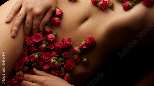 Plakat Zmysłowy żeński ciało z róża kwiatami