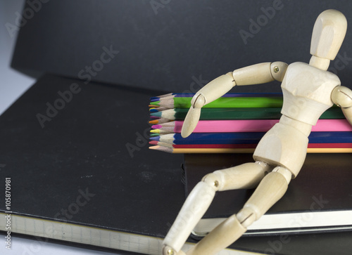 Fotografía Wood Puppet Sitting on Sketchbook with Colour pencils