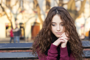 Wall Mural - sad woman sitting on bench in a park