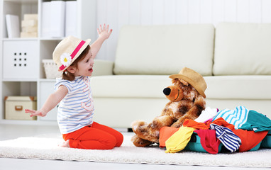 Wall Mural - happy child girl collect suitcase on vacation