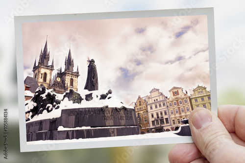 Cuadros en Lienzo hand holds snapshot of tyn square in prague on blurred backgroun