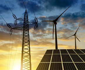 Solar panels with wind turbines and electricity pylon at sunset. Clean energy concept.