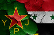 flags of YPJ and Syria painted on cracked wall