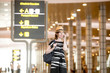 © fizkes - Woman making call in airport