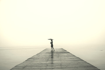 Wall Mural - woman with black umbrella looking infinity in a surreal place