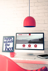 red workspace with computer showing web design