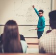 © Nejron Photo - Multinational group of cheerful students taking an active part in a lesson while sitting in a lecture hall.
