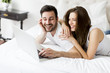 © BGStock72 - Young couple with laptop in the bed