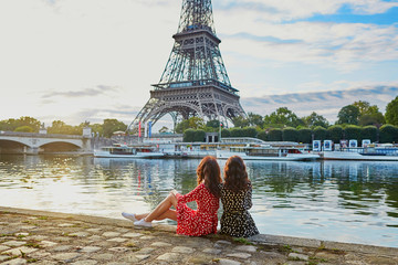 Wall Mural - Beautiful twin sisters near the Eiffel tower in Paris, France