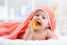 Cute Baby With Teether Under A Hooded Towel After Bath
