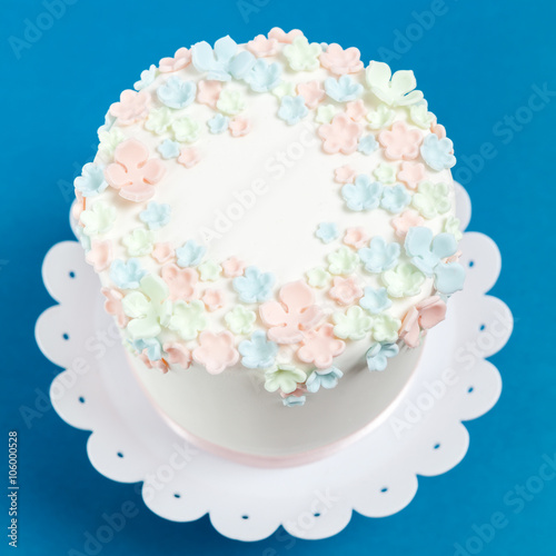 söt tårta med pastel färgade blommor mot turkos bakgrund - Buy ...