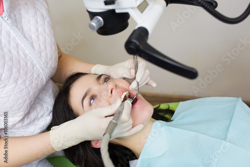Poster professional dentist examination patient with microscope at the office