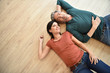 Upper view of couple laying on wooden floor