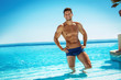 © kiuikson - Summer photo of muscular smiling man in swimming pool