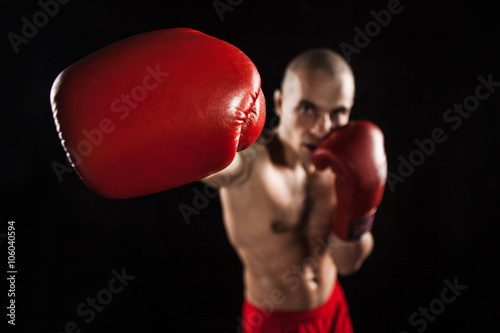 Εκτύπωση καμβά The young man kickboxing on black  with kapa in mouth