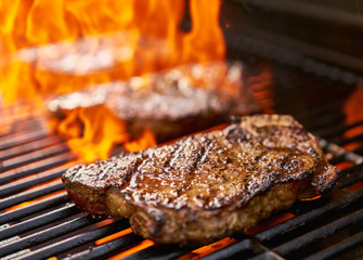 Wall Mural - grilling new york strip steaks over flames