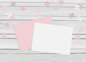 Baby shower, birthday day or wedding mockup scene with envelope, blank card, paper flowers