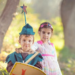 Cute little children dressed up as a fairy and a knight playing in a dreamlike nature