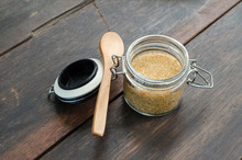 Brown Sugar With Wooden Spoon In Bottle On Wood Table, Selective Focus.