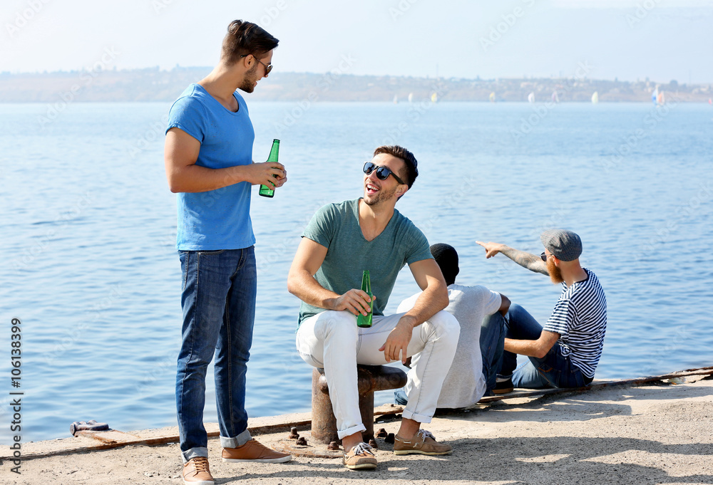Young men talking on the riverside