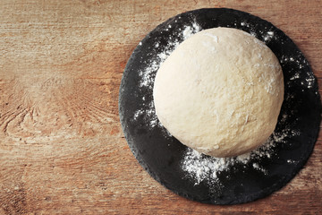 Poster - Fresh prepared dough on a wooden board, close up