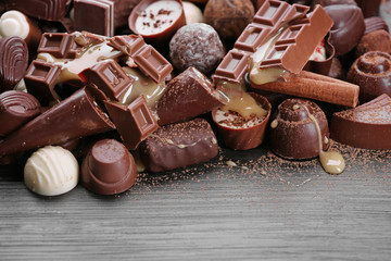 Sticker - Assortment of tasty chocolate candies and cinnamon on wooden table background