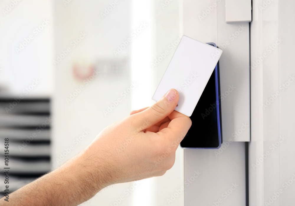 Security alarm keypad with male hand and card, closeup