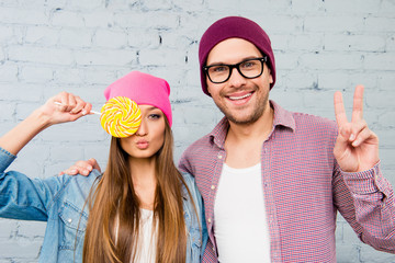 Poster - Woman holding lollipop near eyes  and man gesturing with two fin