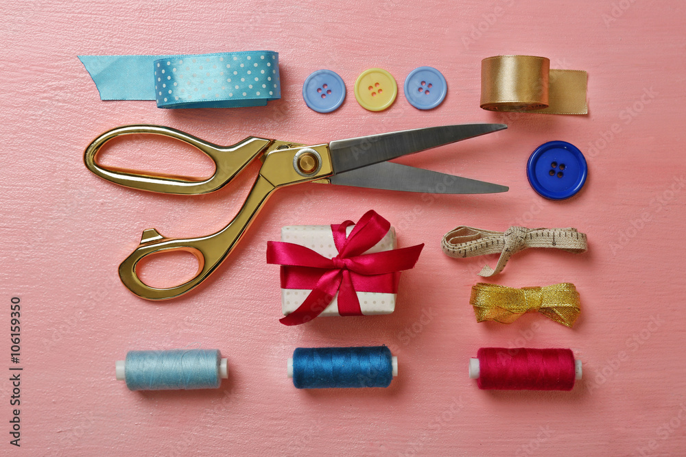 Sewing creative accessories on pink surface, top view