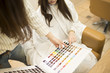 © Monet - Hairdresser is showing the hair of the color swatch to women