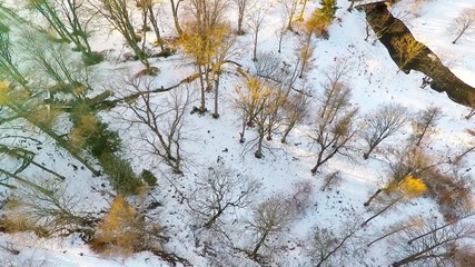 Wall Mural - Winter landscape. Aerial footage. Sunset. River and sea coast. Camera tilt down.