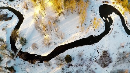Wall Mural - Winter landscape. Aerial footage. Sunset. River and sea coast. Camera tilt down.