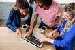 © WavebreakMediaMicro - Young female friends using laptop while drinking coffee