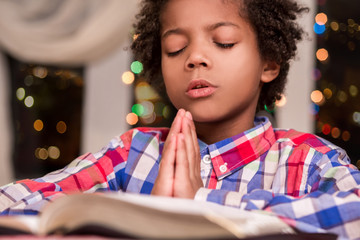 Afro child praying.