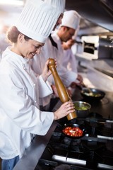 Wall Mural - Chef sprinkling pepper on tomatos 