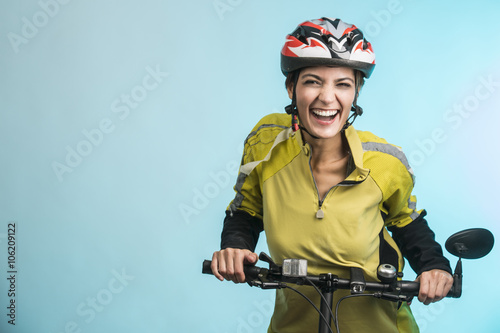 Fotografie, Obraz Donna Ciclista con casco su sfondo celeste sorride in camera