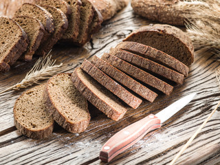 Wall Mural - Sliced black bread on the wooden plank.