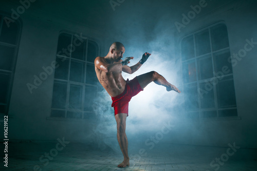 Fototapety Kickboxing  mlody-mezczyzna-kickboxing-w-niebieskim-dymie
